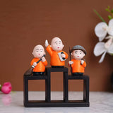 Load image into Gallery viewer, Webelkart Premium Set of 3 Child Monk Showpiece for Home and Office Decor| Child Monk Showpiece for Gift| Showpiece for Car Dashboard (Polyresin,Orange)